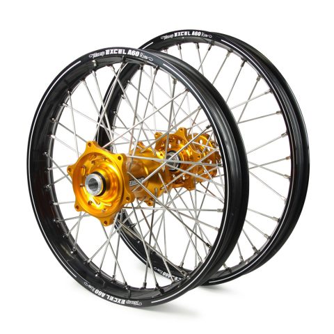 Two black spoked wheels with gold hubs leaning together on a white background, showcasing rims and spokes.