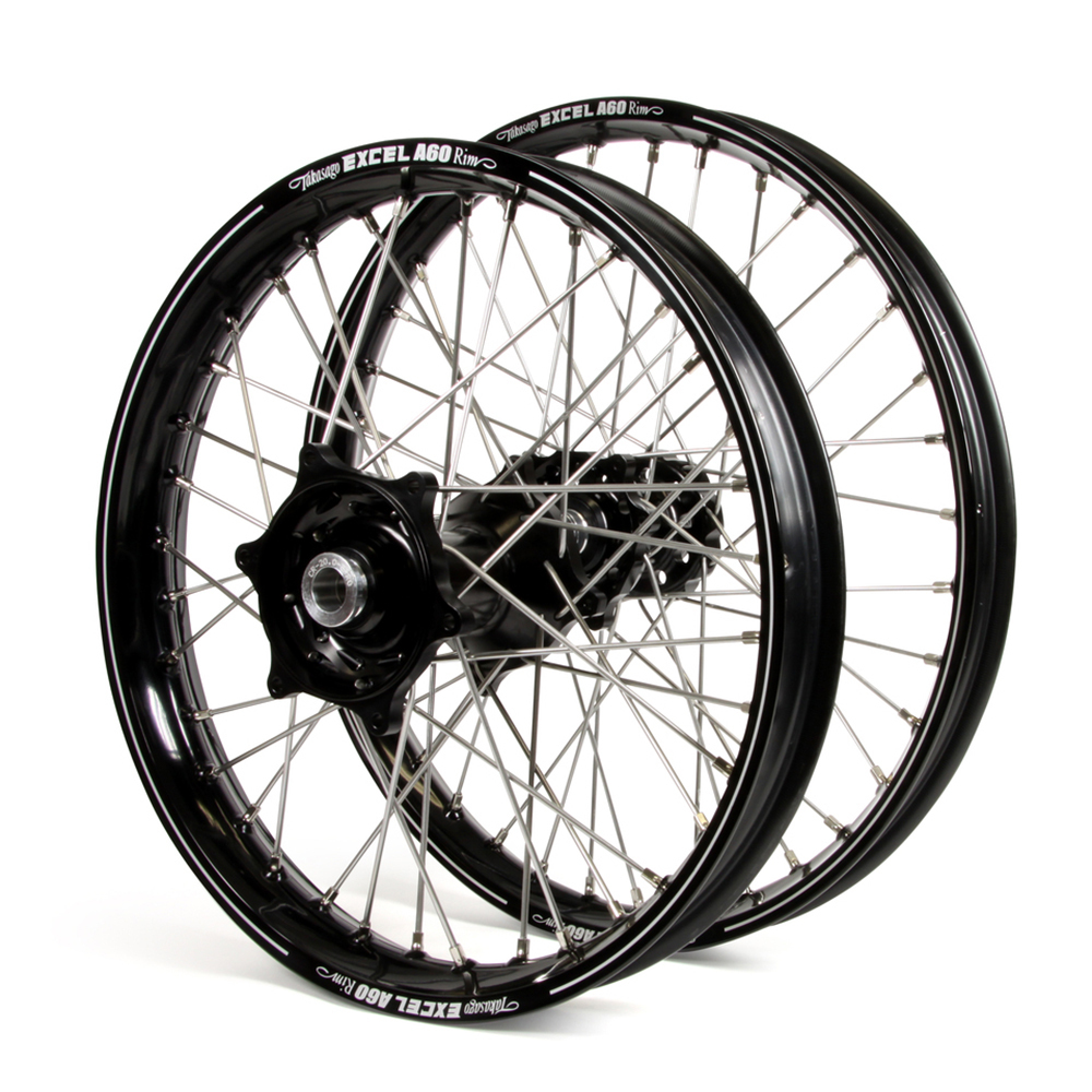 09fbbf_f016c43c885e44f3991686ddac8b8278mv2.jpg - Inmotion Suspension Two black bicycle wheels with silver spokes and central hubs resting together.