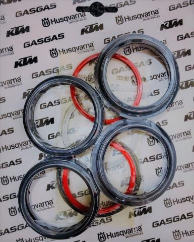 Four black rubber gaskets with red inner rings arranged on a branded backdrop (GASGAS, Husqvarna, KTM).
