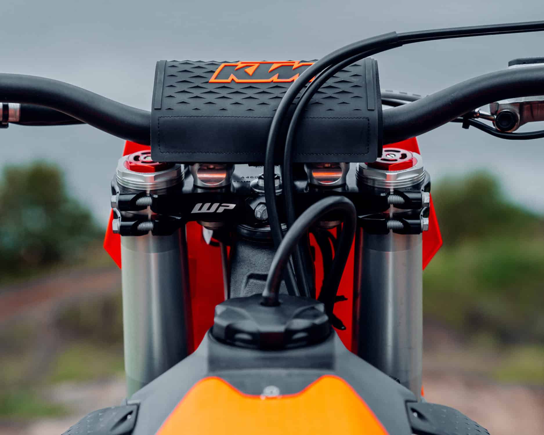 xact pro 3 - Inmotion Suspension Close-up of a KTM dirt bike from the rider’s perspective, showing the orange front fender, handlebar, and textured head tube with KTM logo visible.