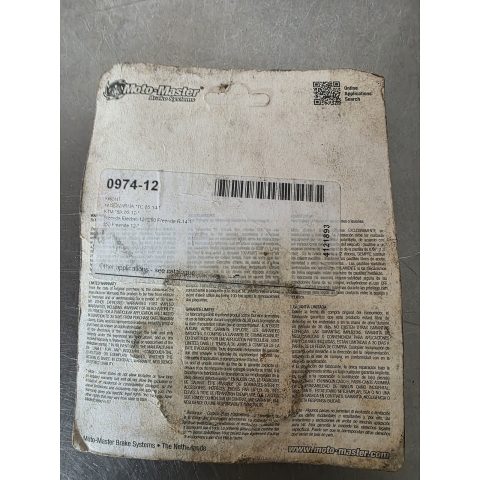 Worn white Moto-Master Brake Systems label with barcode on a dirty surface and a small QR code in the corner (informational packaging label).