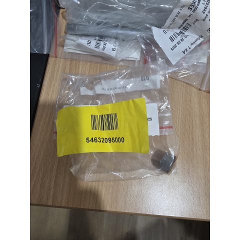 Top-down view of clear plastic bags with white labels and a yellow label with barcode on a wooden desk.