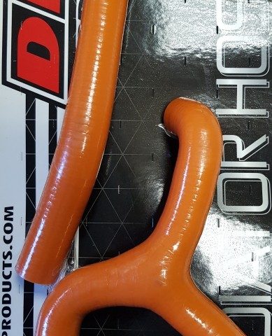 Two orange silicone radiator hoses with elbow bends, displayed on a DRC radiator hose kit packaging.